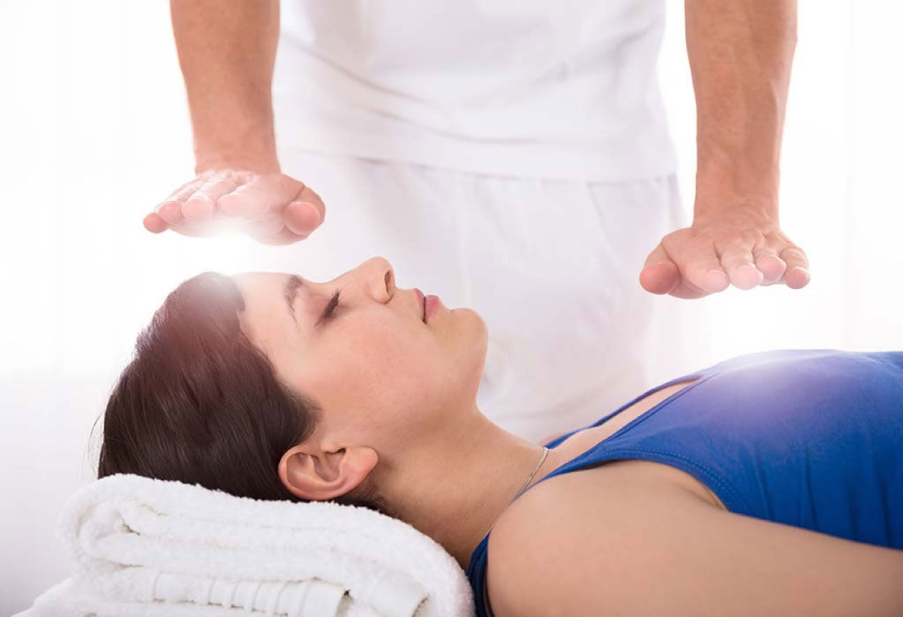 Hands held above a person lying down during Reiki